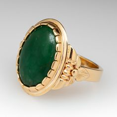 This wonderful ring is centered with one (1) oval cabochon cut natural jadeite jade set into a closed back scalloped bezel setting. Engraved floral details accent the shoulders of the ring. The ring measures 20.6mm at the top, rises 5.9mm above the finger, tapering to 3.5mm wide and 1.6mm thick at the base of the shank. This ring is currently a size 7. The jade shows overall wear on the surface. Vintage Emerald Oval Cabochon Ring With Polished Finish, Vintage Polished Emerald Ring With Oval Cabochon, Vintage Oval Cabochon Emerald Ring With Polished Finish, Formal Oval Jade Emerald Ring, Fine Jewelry Oval Jade, Formal Oval Jade Jewelry, Heirloom Jade Jewelry For Formal Occasions, Vintage Oval Jade Emerald Ring, Vintage Oval Jade Rings