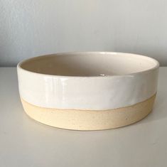 a white and yellow bowl sitting on top of a table