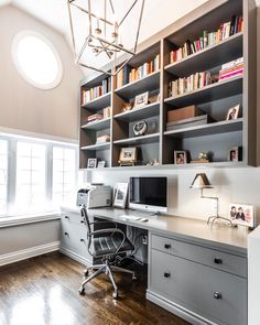 a home office with built in bookshelves and desk