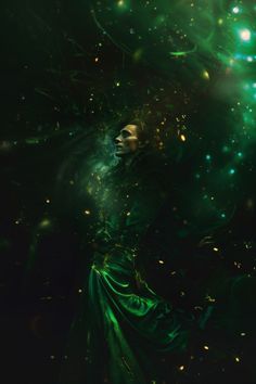 a woman in a green dress is floating through the air with her head above water