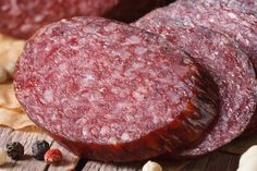 two slices of sausage sitting on top of a wooden table