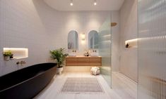 a bath room with a tub a sink and a mirror on the wall in it