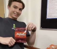 a man holding up a bag of chips