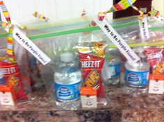 several bottled water bottles are lined up on a counter top with ribbons and signs attached to them