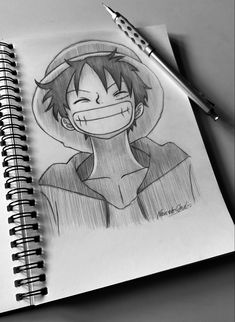 a pencil drawing of a person with an evil smile on his face and head, next to a pen