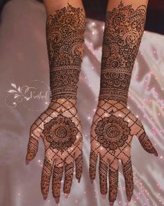 two hands with henna designs on them