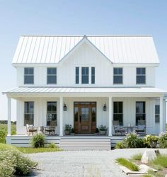 a large white house with lots of windows on it's front door and porch