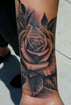 a black and white rose tattoo on the wrist