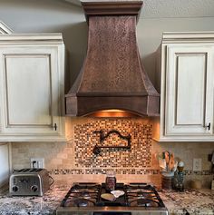 a stove top oven sitting inside of a kitchen next to white cabinets and counter tops