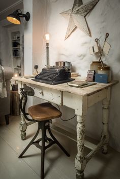 an old fashioned desk with a typewriter on it and a lamp next to it