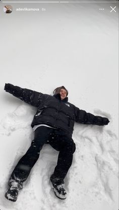 a person laying in the snow with their arms out and legs spread out, smiling