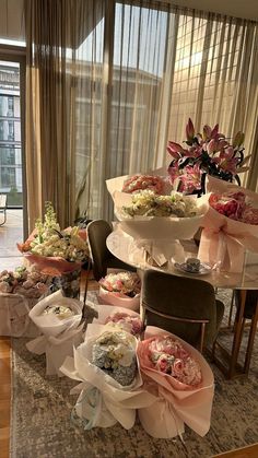 a room filled with lots of vases and flowers on top of each other in front of a window