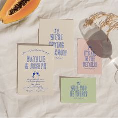 some cards that are sitting on top of a piece of paper next to a slice of papaya