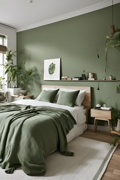 a bed with green sheets and pillows in a bedroom next to a plant filled wall