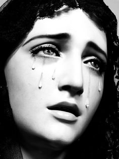 a black and white photo of a woman with tears on her face