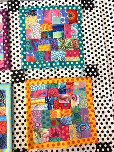 three colorful patchwork quilts are displayed on polka dot fabric, each with different designs