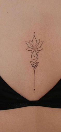 a woman's back with a tattoo on her stomach and a flower in the middle