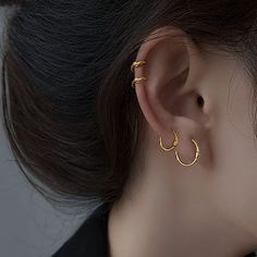 a close up of a person wearing gold earrings