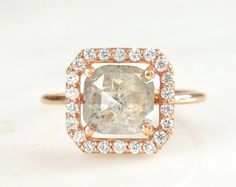 an engagement ring with a fancy cushion cut diamond surrounded by small round brilliant pave diamonds