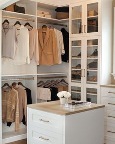 an organized closet with white cabinets and drawers