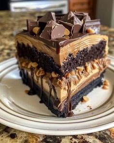 a piece of cake on a plate with chocolate frosting and chopped nuts in the middle