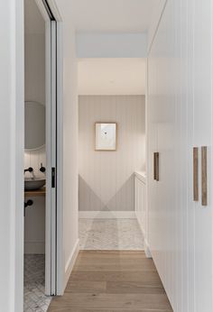 an empty hallway with white walls and wood floors