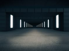 an empty dark room with light coming in from the windows, and some bright lights shining down on the floor