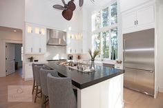 a kitchen with white cabinets and stainless steel appliances, along with an island in the middle