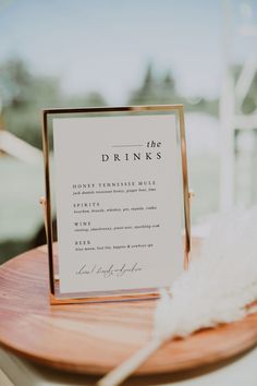 a sign that says thank you on top of a wooden table with a white feather