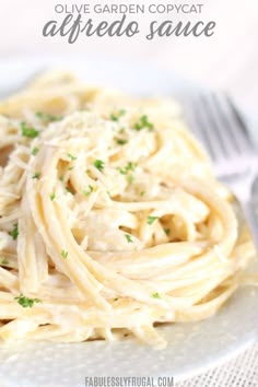 a white plate topped with pasta covered in parmesan cheese and garnished with parsley