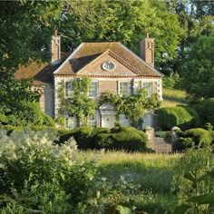 an old brick house surrounded by trees and bushes