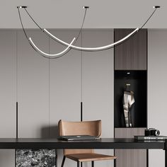 a table with some chairs and lights hanging from it's sides, in front of a gray wall