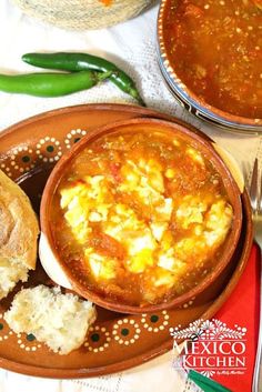 a bowl of soup and some bread on a plate