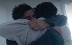 two people hugging each other in a room