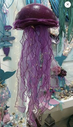 a purple jellyfish hanging from the ceiling in a room filled with other items and decorations