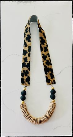 "Leopard Calf Hair on Hide Leather Strap / Long Statement Layering Necklace / Tan Coconut Wood Bead / Recycled Glass Bead / Fabric Jewelry * Handmade item made in a clean, sanitized, & safe environment. Made with Love ❤️❤️ * Tan coconut wood disk bead  * Black recycled glass bead * Black & brown leopard on hide calf hair leather strap 1.5\" thick  * Animal print jewelry  * Length- 18\" top to Bottom * Gold wood spacer beads  Many styles are available & inventory is growing daily!  Be sure to che Brown Large Beads Long Necklace, Fabric Jewelry Handmade, Elegant Multi-strand Necklace With Wooden Beads, Leopard Jewelry, Trendy Leopard Print Dangle Jewelry, Luxury Brown Hand-strung Beaded Necklaces, Bead Styles, Animal Print Jewelry, Long Leather Necklace