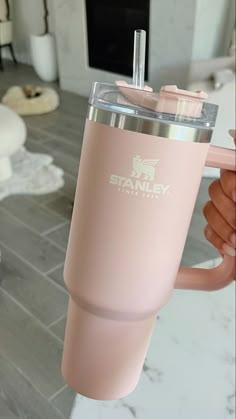 a person holding up a pink tumbler cup