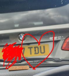 a heart drawn on the back of a car with a wooden sticker in front of it