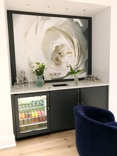 a large white flower is on the wall behind a bar with drinks in front of it