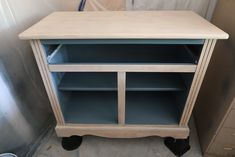 a wooden cabinet with two shelves on wheels