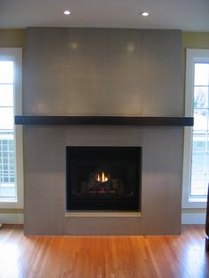 an image of a fireplace in the middle of a room with wood floors and windows