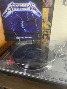 a record player with an electric guitar on it's turntable in front of a poster