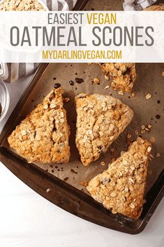 baked oatmeal and raisin scones on a baking sheet with two bowls of oats