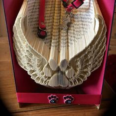 an open book with red collars and paw prints on it, sitting in a pink box