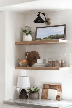 the shelves in the kitchen are filled with dishes and vases on top of them