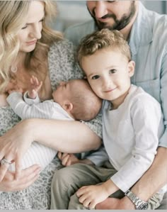 a man and woman are holding a baby while the child is being held by his mother