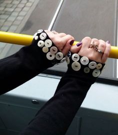 two hands holding onto a yellow pole with buttons on it