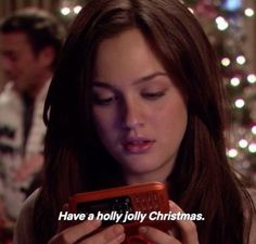 a woman looking at her cell phone with the words have a holly holly christmas on it