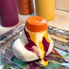 an orange, yellow and white object sitting on top of a metal tray next to other bottles