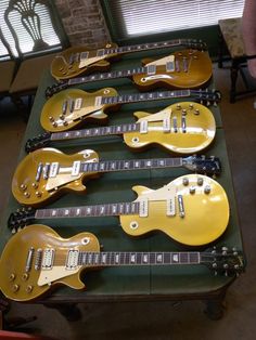 five electric guitars lined up on a table